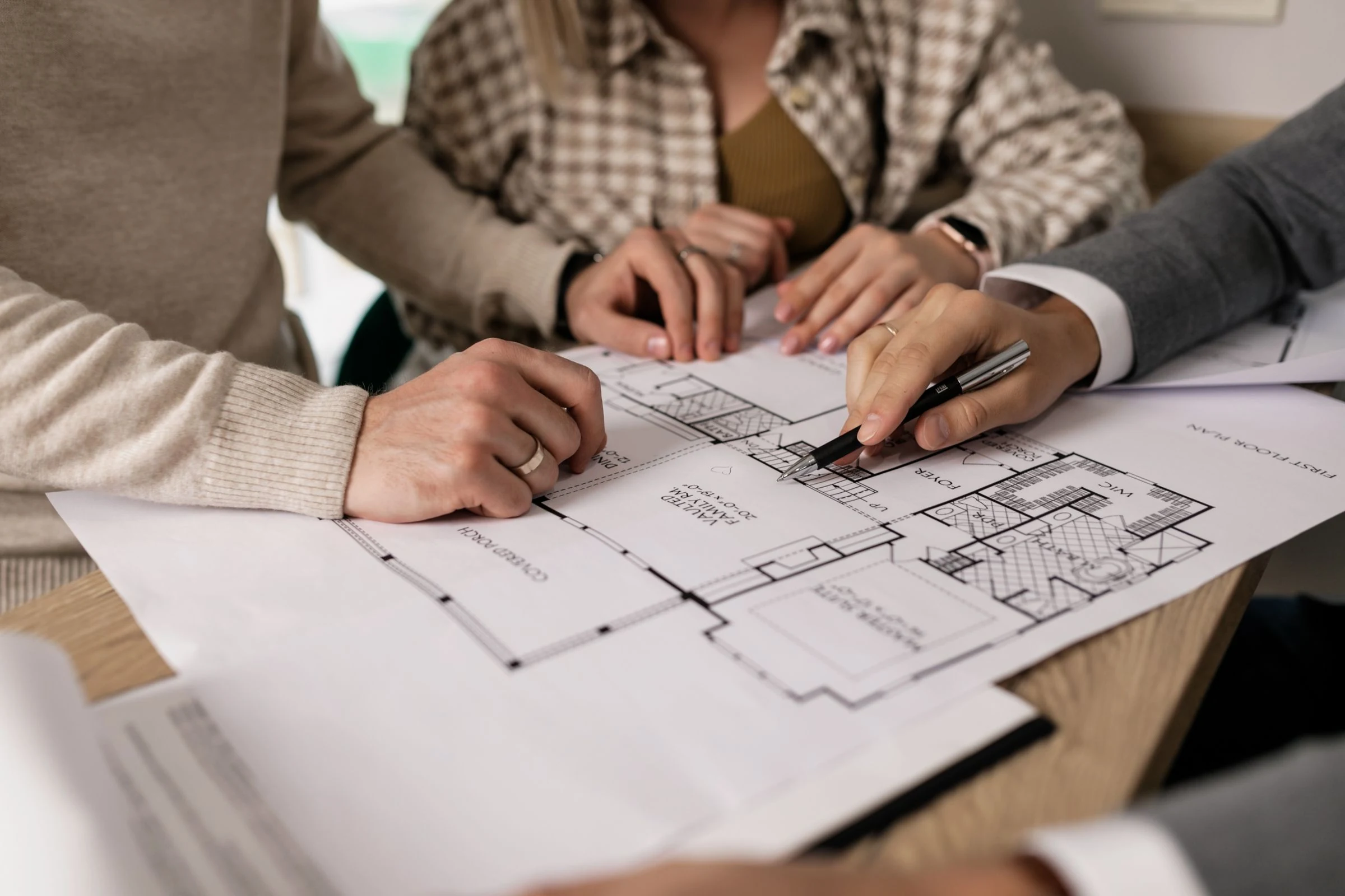 Des personnes échangent autour du plan d’un logement.