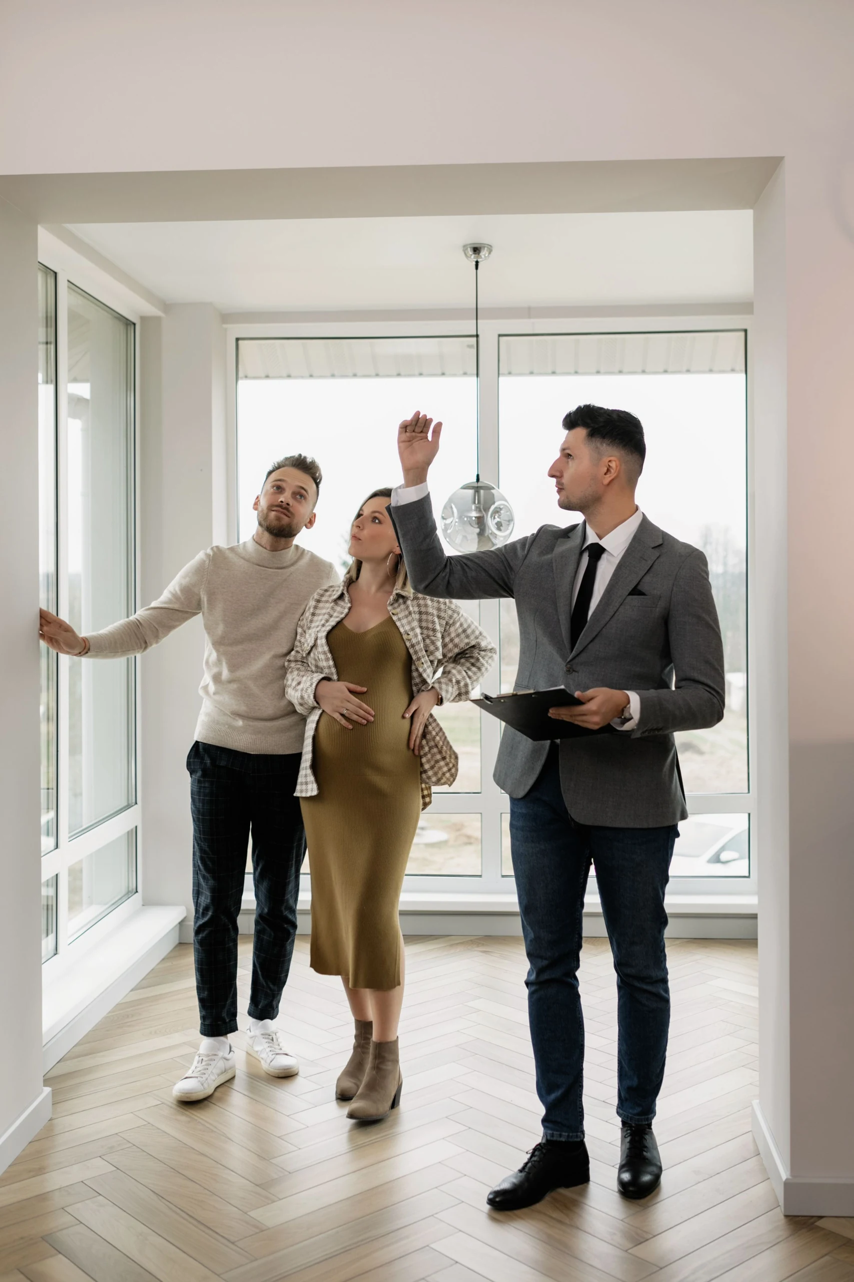 Un conseiller accompagne un couple lors de la visite d’un logement lumineux