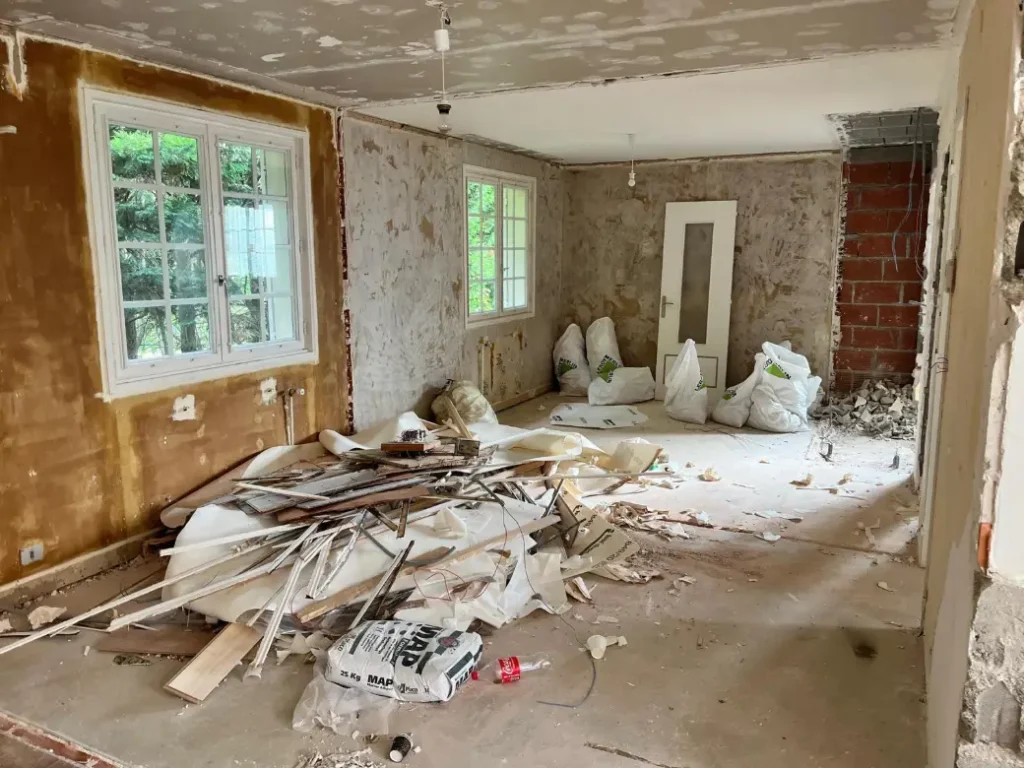 Dépose des papiers peints et préparation des murs pendant le chantier de rénovation de la maison
