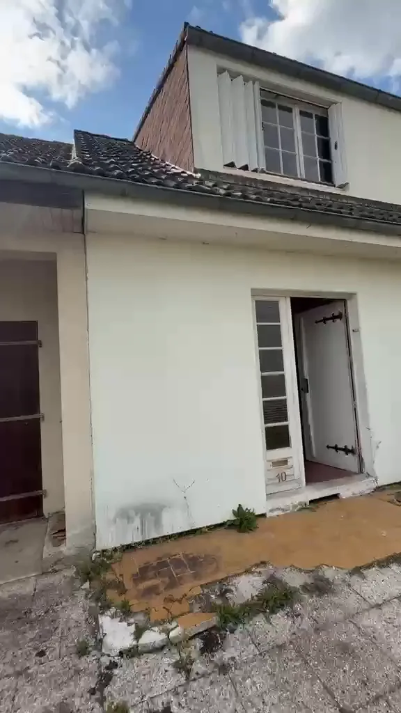 Façade d’un pavillon avant rénovation : enduit défraîchi, porte ancienne et abords dégradés