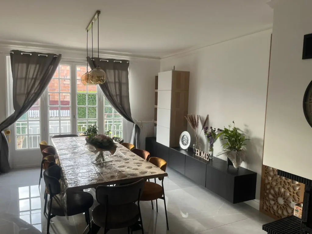 Salle à manger rénovée et ouverte sur le jardin après la rénovation d’une maison des années 1980 accompagnée par Signature Travaux